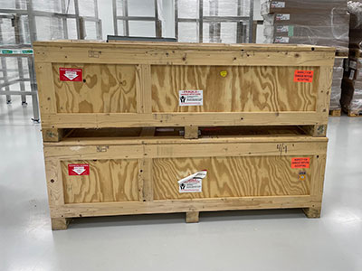 two Impak machine crates sitting atop each other